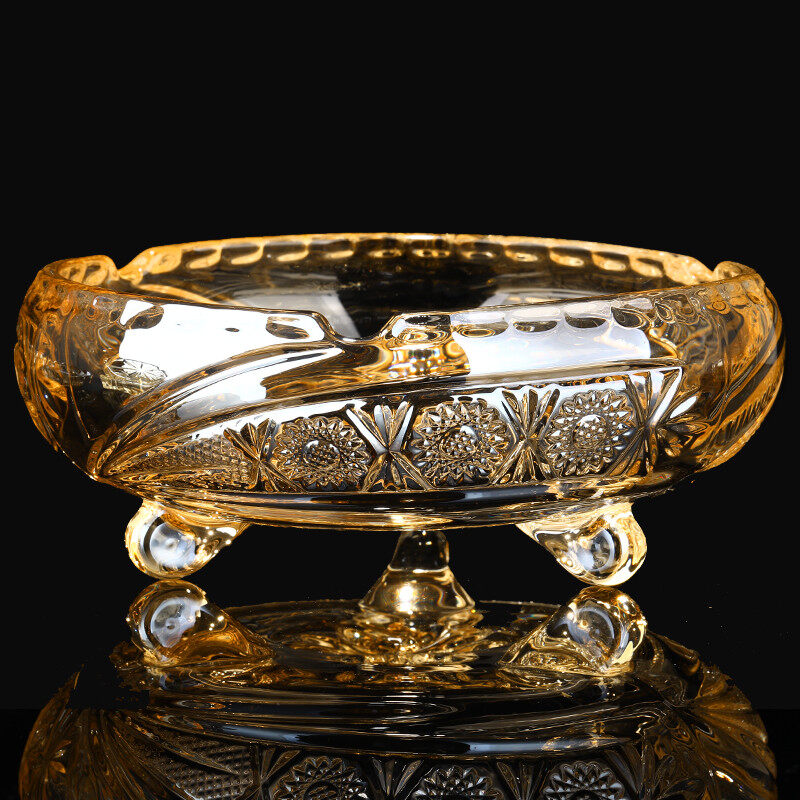 Three-legged round golden ashtray